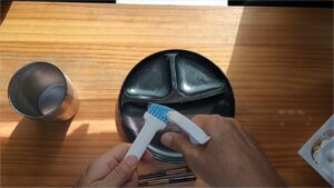 食器洗いブラシに洗剤薄め液をかける